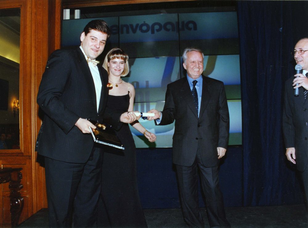 Ένατο καλύτερο εστιατόριο για το 1998 είναι το «L’ Abreuvoir». Η Κλαίρη και ο Σπύρος Κώτσης παραλαμβάνουν το βραβείο τους από τον διευθύνοντα σύμβουλο της Grecotel, Νίκο Δασκαλαντωνάκη.