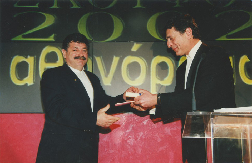 Ο Στέλιος Κούλογλου παραδίδει το έκτο βραβείο του 2002 στον Λευτέρη Λαζάρου.