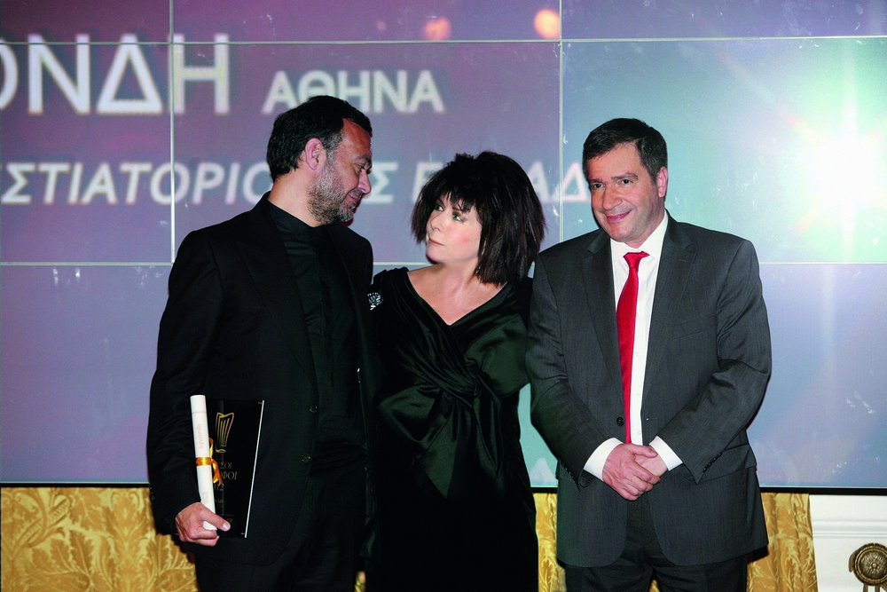 Ο Απόστολος Τραστέλης από τη «Σπονδή» με το βραβείο του καλύτερου εστιατορίου της Ελλάδας και δίπλα του η εκδότρια του «Αθηνοράματος» Άννη Ηλιοπούλου και ο Δήμαρχος της Αθήνας Γιώργος Καμίνης (2012)