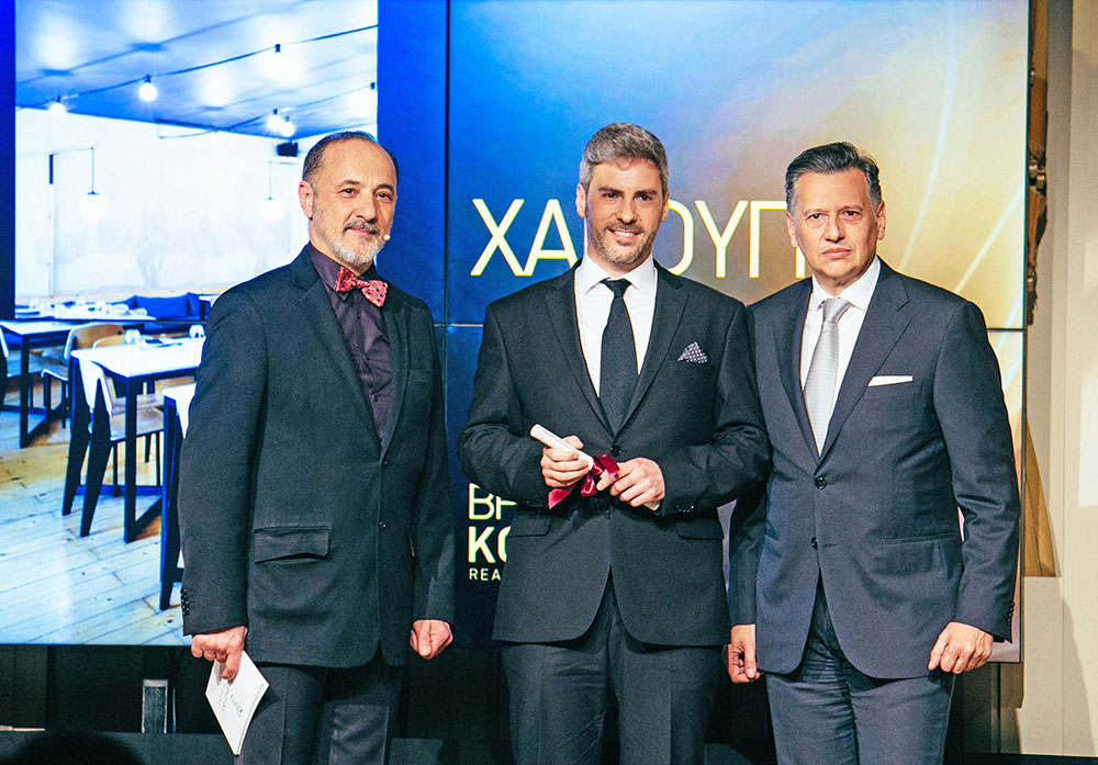 Το Βραβείο Κοινού, το οποίο ανέδειξαν οι αναγνώστες του Αθηνοράματος, απένειμε στον Μανώλη Παπουτσάκη για το εστιατόριο «Χαρούπι» της Θεσσαλονίκης ο Διευθυντής Μάρκετινγκ της Ολυμπιακής Ζυθοποιίας Νίκος Μιχαλόπουλος, εκπροσωπώντας τη μπίρα Kaiser, χορηγό του βραβείου. Μαζί τους ο συμπαρουσιαστής της βραδιάς Στέλιος Μάινας.